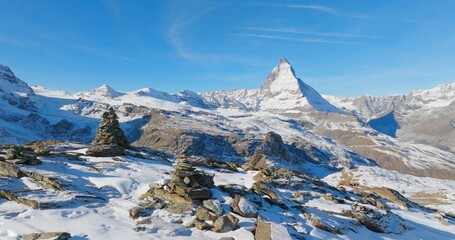 Majestic mountain peaks full of stacked rock hiker cairns with famous Matterhorn view background...