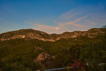 paisaje de montaña al amanecer con la luna y nubes