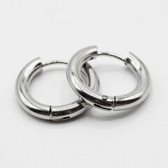 Fake hard earring. White silver ear ring. Imitation jewelry. Accessory for rockers, rap, hip-hop, bikers, emo. Creation of a scenic view. Pirate style.