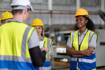 Portrait confident African American businesswoman with team working with machine at factory	
