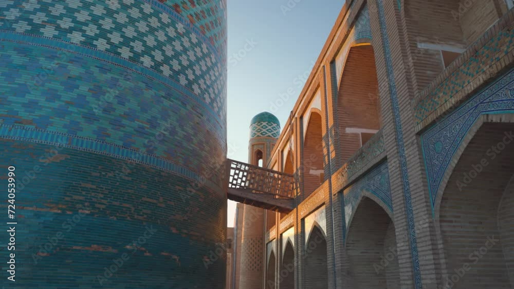 Wall mural tourist woman in ethnic dress near kalta minar in ichan kala of khiva