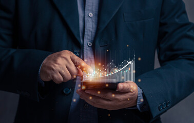 Businessman points at virtual screen of mobile phone at stock graph. The concept of stock trading via mobile phone. Financial stock exchange graph. Trade stock and bitcoin currency. Online trade.
