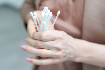Cotton buds in hand isolated on white background. - obrazy, fototapety, plakaty