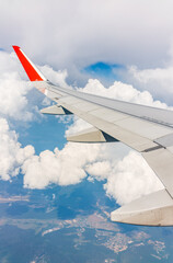 View from the airplane window at a beautiful cloudy sky and the airplane wing