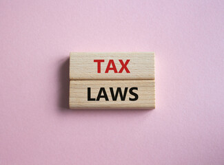 Tax Laws symbol. Concept word Tax Laws on wooden blocks. Beautiful pink background. Business and Tax Laws concept. Copy space