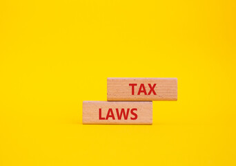 Tax Laws symbol. Concept word Tax Laws on wooden blocks. Beautiful yellow background. Business and...