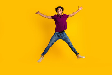 Fototapeta na wymiar Full length photo of cheerful good mood guy wear stylish magenta clothes jump up with open hands isolated on yellow color background