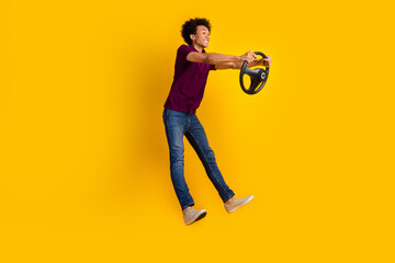 Photo of cheerful funky guy look empty space hold steering wheel promote car drive education school isolated on yellow color background