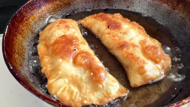 fried chebureks in a frying pan
