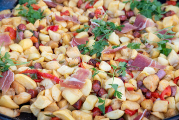 Potato salad with bacon and red pepper, closeup of photo