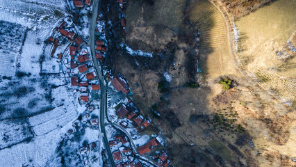Drone view of Brzece on Kopaonik with snow on the north side of the mountain and green grass in the...