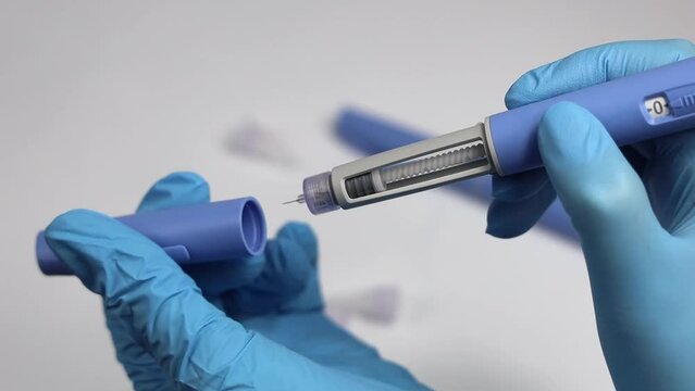 Hands in examination gloves demonstrate an injection with insulin for diabetics.