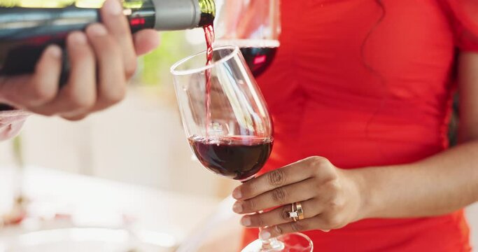 Couple, hands and bottle of red wine for celebration of love, romance and valentines day on their anniversary. People or lover on date with glasses, drinks and alcohol for toast, success and luxury