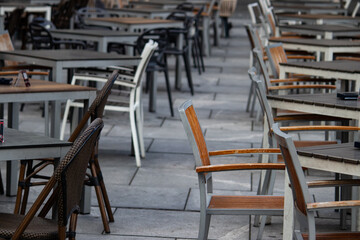 Empty chairs in coffee bar, outdoor seating but empty due to economic crisis and cold winter weather, on the streets of urban metropolis