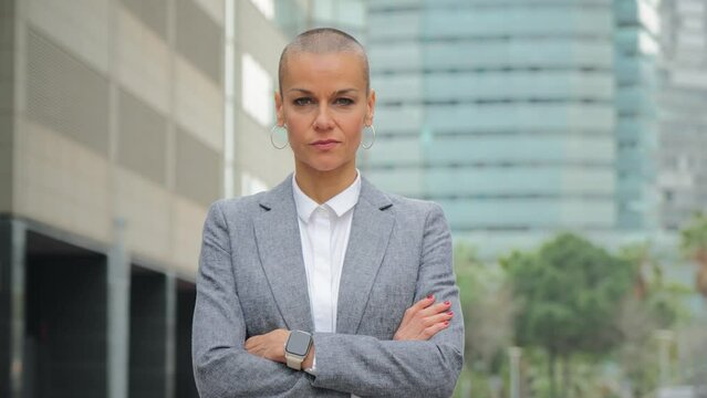 Individual portrait of a serious arms crossed businesswoman with short hair looking at camera with pensive expression. Lawyer, clerk or executive staring front at workplace. Real confident female