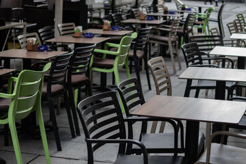 Empty chairs in coffee bar, outdoor seating but empty due to economic crisis and cold winter weather, on the streets of urban metropolis
