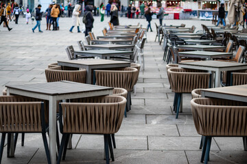 Empty chairs in coffee bar, outdoor seating but empty due to economic crisis and cold winter weather, on the streets of urban metropolis