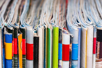 Old colored paper magazines in row, close-up