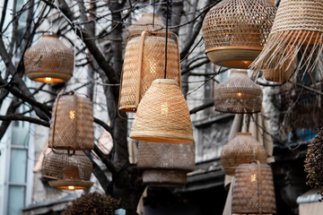 Decorative lanterns fairy lights made of handicraft bamboo braid basket, installed on tree in public