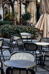 Empty chairs in coffee bar, outdoor seating but empty due to economic crisis and cold winter weather, on the streets of urban metropolis