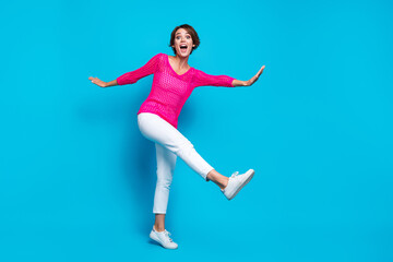 Fototapeta na wymiar Full length photo of pretty impressed woman wear knitted neon shirt walking having disco fun empty space isolated blue color background