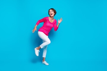 Full length photo of carefree positive woman wear knitted neon shirt dancing disco empty space isolated blue color background