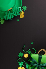 St. Paddy's surprise: s leprechaun's treasure chest. Top view shot of gift box, leprechaun hat, party eyewear, traditional decor on black background with space for greetings