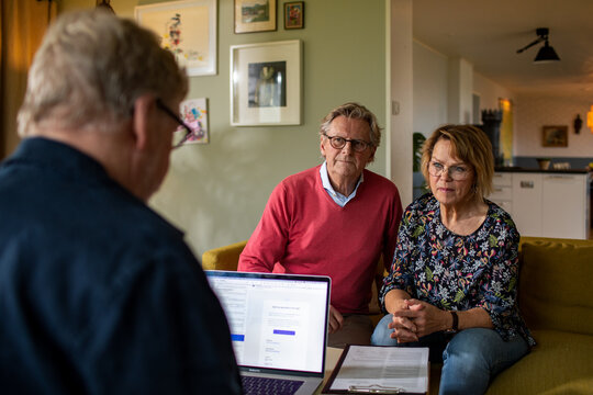 Worried senior couple talking to their financial advisor at home