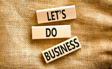 let is do business symbol. Concept words let is do business on beautiful wooden blocks. Beautiful canvas table canvas background. let is do business concept. Copy space.