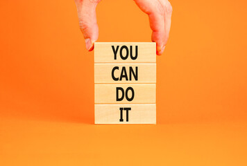 You can do it symbol. Concept word You can do it on beautiful wooden block. Beautiful orange table orange background. Businessman hand. Business motivational you can do it concept. Copy space.