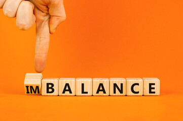 Balance or imbalance symbol. Concept word Imbalance or Balance on beautiful wooden cubes. Beautiful orange background. Businessman hand. Business balance or imbalance concept. Copy space.