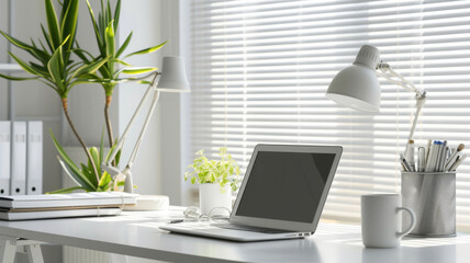Workspace with Laptop, Desk Lamp, and Plant by Window Blinds
