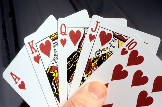 a hand holding four cards with hearts on them