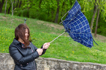 The wind blows away the woman and breaks the umbrella