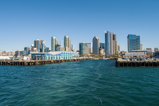 the port of san diego with a view of the city architecture, its buildings and people on a sunny winter day near the uss midway