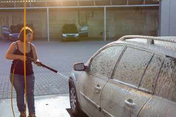 Woman washing car at self-service car wash