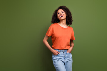 Photo of cheerful sweet lady dressed orange t-shirt looking empty space isolated khaki color...