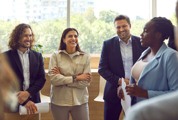 Group of business people standing in a circle and talking discussing job and work projects in the...