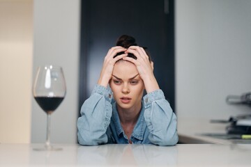 Woman with a glass of wine depressed, lonely on Valentine's Day holiday February 14