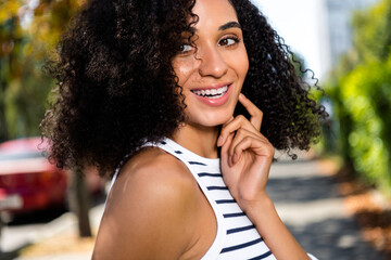 Photo of positive adorable cute cheerful girl in town park enjoying sunny weather pastime good mood...