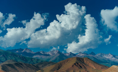 Picturesque landscape with mountains peaks and clouds