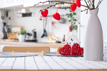 Obraz na płótnie Canvas Key to tiny house of cozy home with Valentine decor on table of kitchen. Gift for valentines day, family love nest. design, project, moving to new house, mortgage, rent and purchase real estate