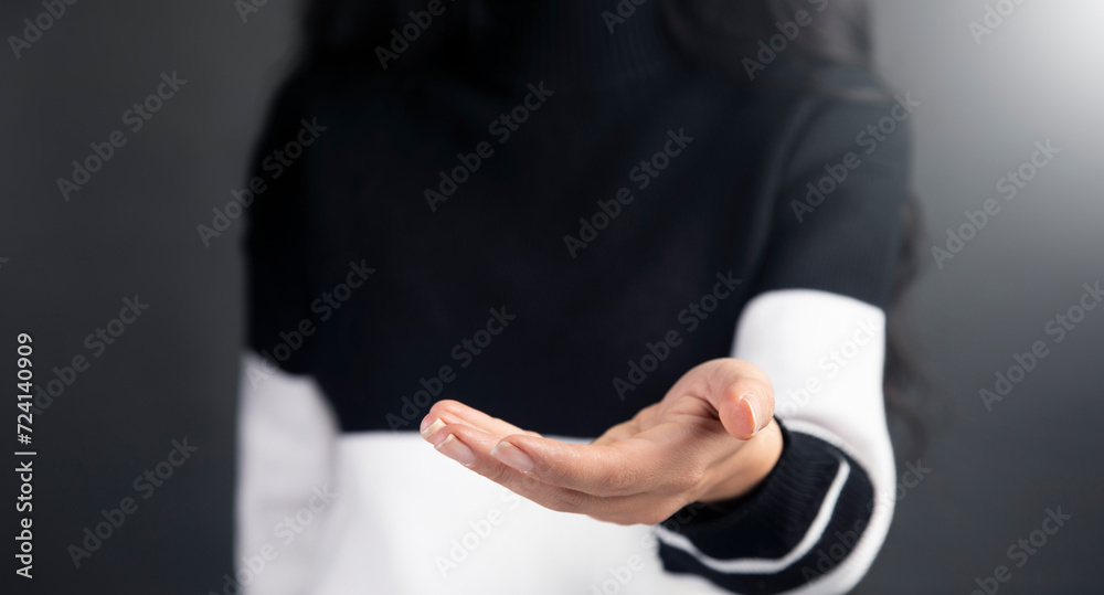 Wall mural a woman in a black and white sweater pointing at something