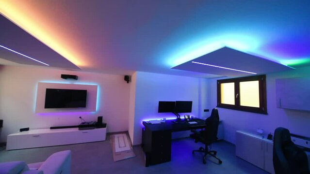 A modern basement room with led lighting coming from plasterboard structures on the ceiling