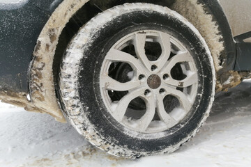 snow stuck to the wheel arch of a car. close-up
