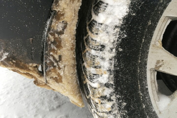 snow stuck to the wheel arch of a car