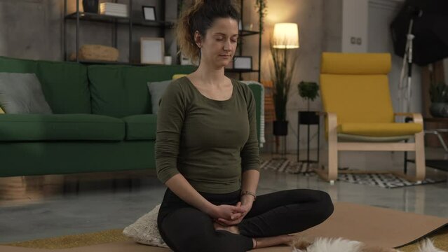 one woman doing guided meditation yoga self care practice at home