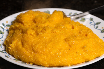 Polenta on plate ready to serve. A traditional cornmeal food.