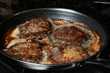 Frying schnitzel in a pan on gas cook top. Home cooking concept. - obrazy, fototapety, plakaty