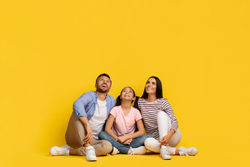Nice Promo. Caucasian Family Of Three Sitting On The Floor, Looking Up